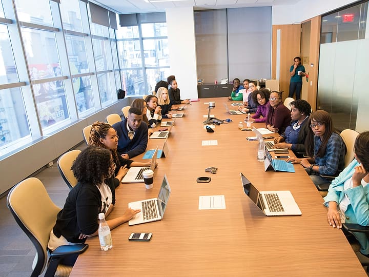 A leader with a team around a long meeting table