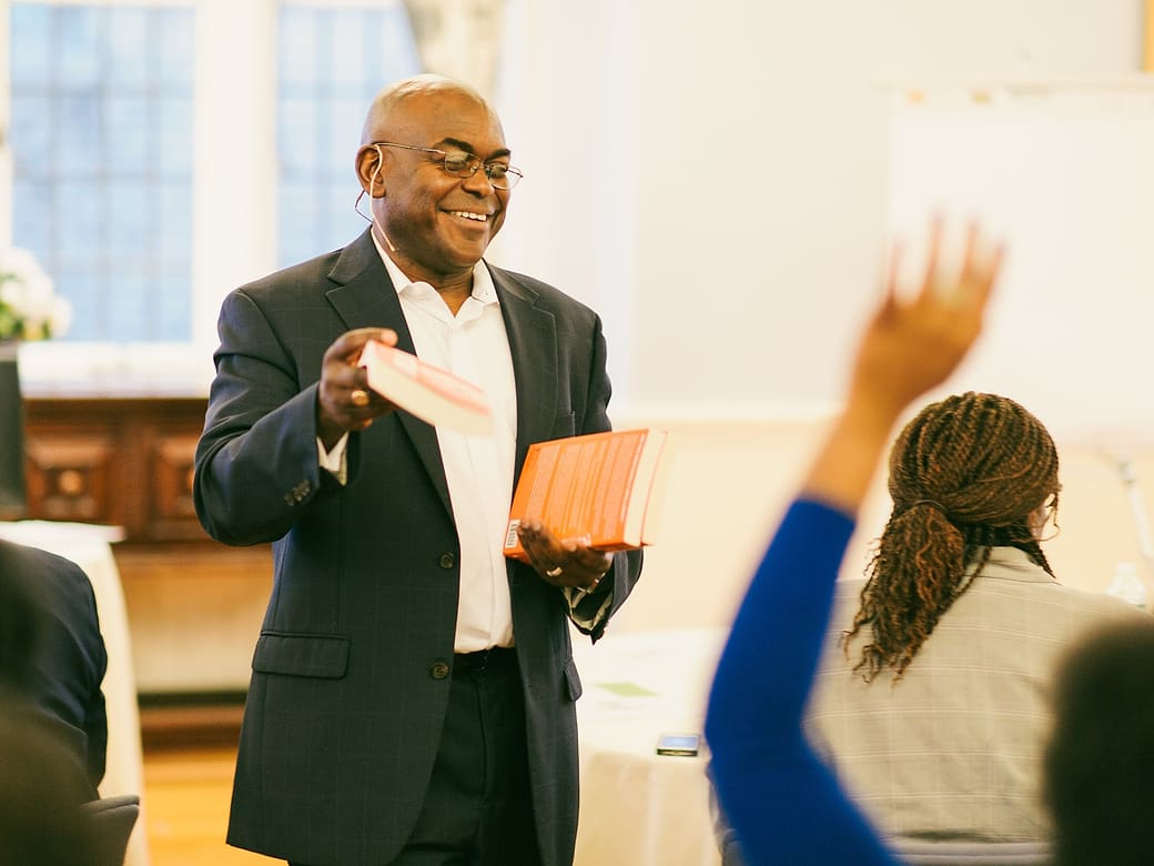 Dr. Rupert A. Hayles Jr. leading a leadership workshop as a participant raises her hand