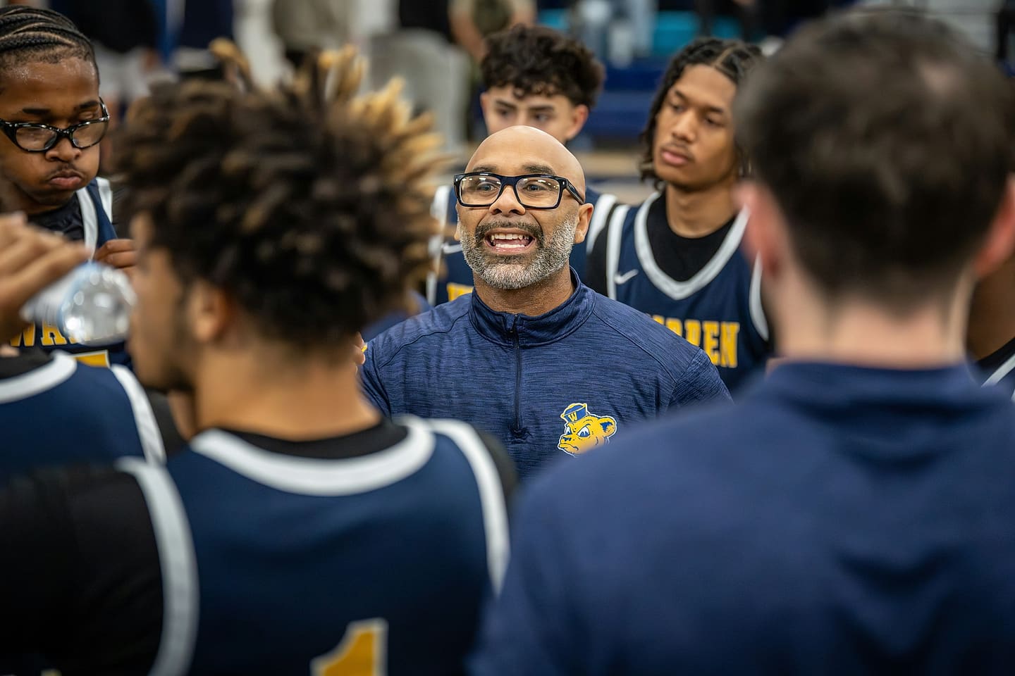 A coach talking with his basketball players in a huddle